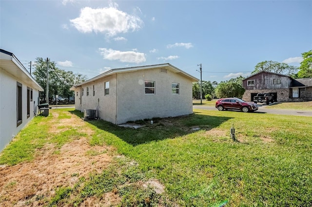 72 Campus View Dr, Orlando, FL 32810 - view of home's exterior featuring central AC, stucco siding, and a yard