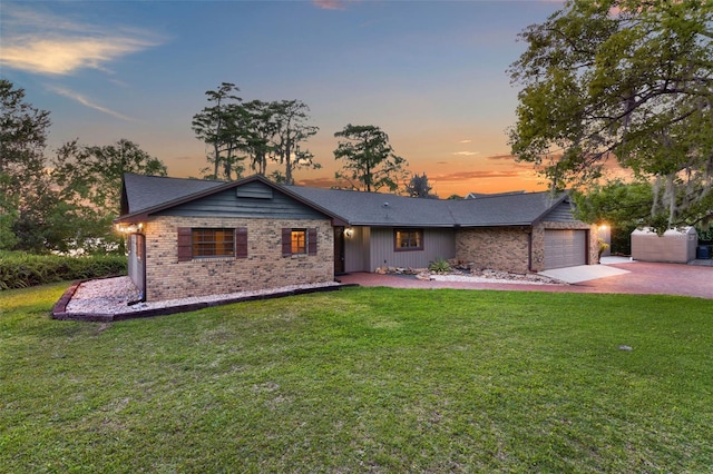 ranch-style house with brick siding, an attached garage, driveway, and a front yard