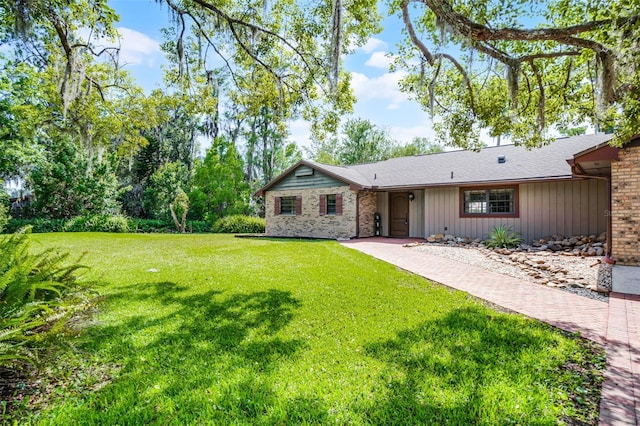 rear view of property with a yard and brick siding