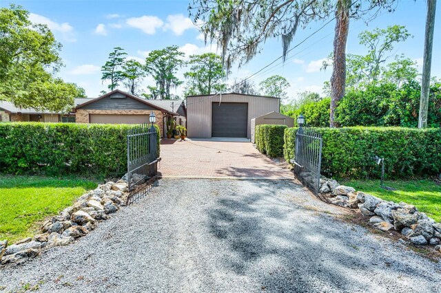 detached garage featuring fence and driveway