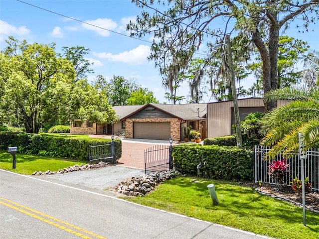 view of front facade with an attached garage, a fenced front yard, driveway, and a front yard