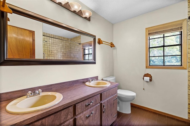 full bath featuring toilet, a wealth of natural light, and a sink