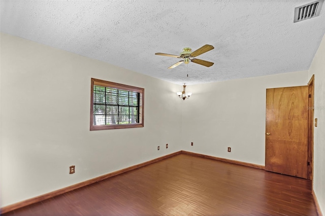 spare room with a textured ceiling, a ceiling fan, baseboards, wood finished floors, and visible vents
