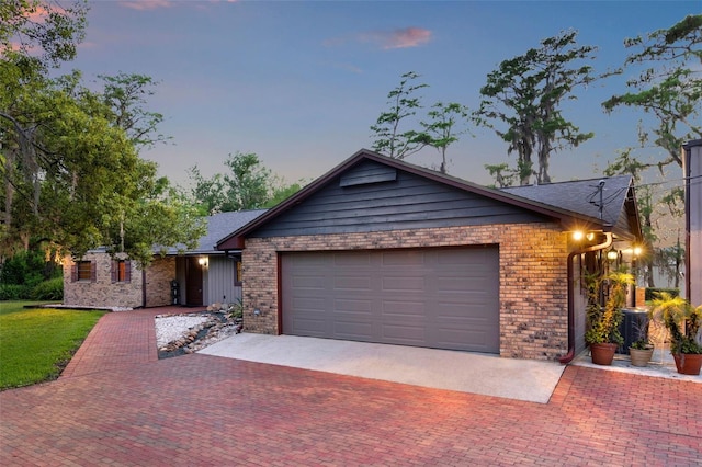 ranch-style house with a garage, a lawn, decorative driveway, and brick siding
