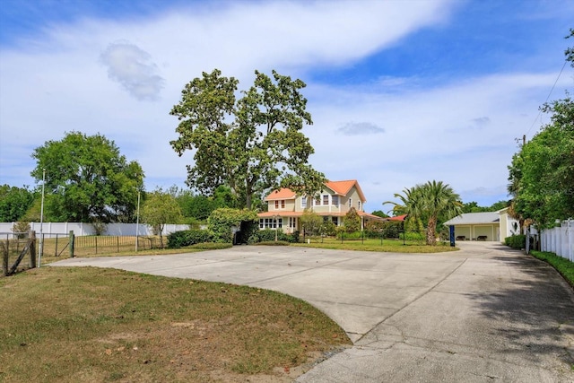 view of front of house featuring fence, a front lawn, and driveway