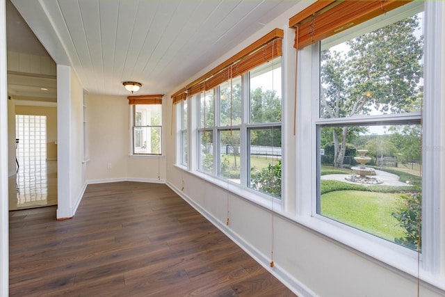 unfurnished sunroom featuring wooden ceiling, wood finished floors, and baseboards
