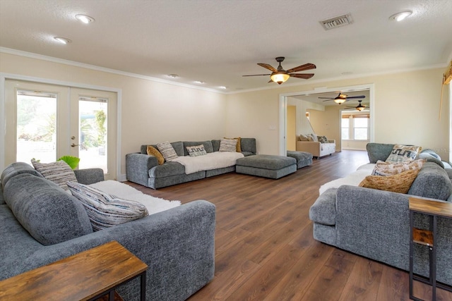 living room featuring visible vents, wood finished floors, ornamental molding, and french doors