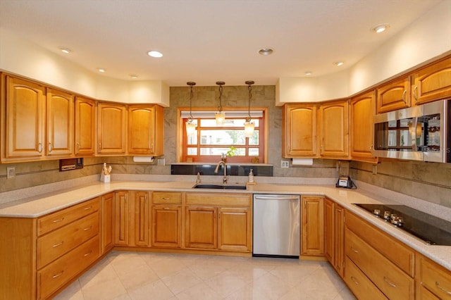 kitchen with light countertops, a sink, appliances with stainless steel finishes, and pendant lighting