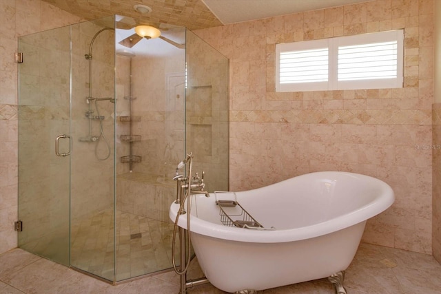 full bathroom with a stall shower, tile walls, a freestanding bath, and tile patterned floors