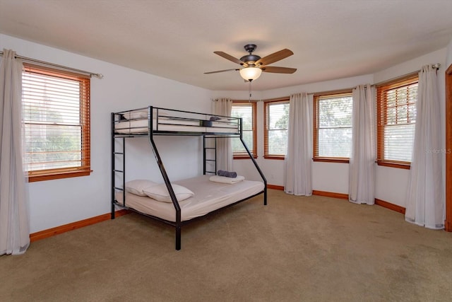 bedroom featuring ceiling fan, baseboards, and light carpet