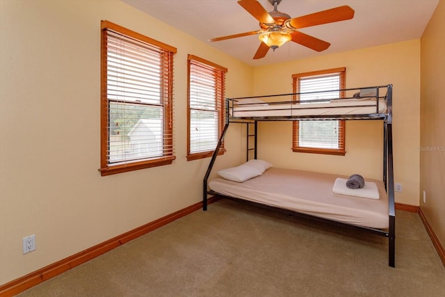 bedroom with ceiling fan, carpet flooring, and baseboards