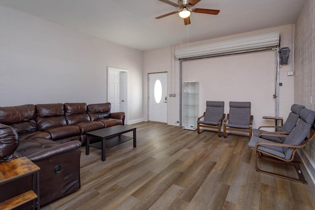 living room featuring baseboards, wood finished floors, and a ceiling fan
