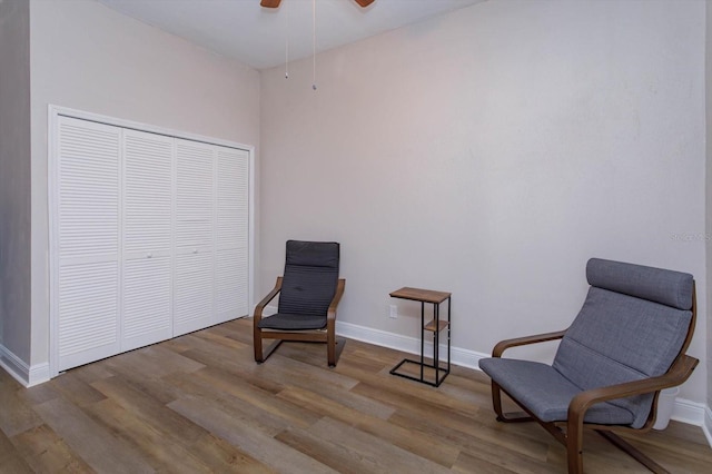 sitting room featuring ceiling fan, wood finished floors, and baseboards