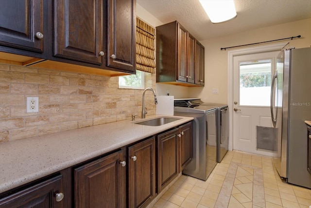 laundry room with light tile patterned flooring, a sink, cabinet space, and washer and clothes dryer