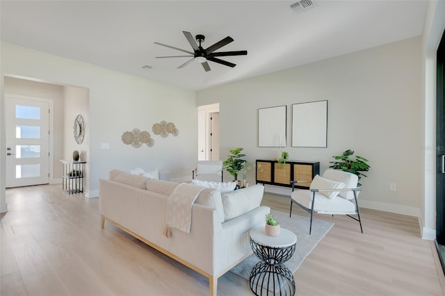 living area with baseboards, visible vents, a ceiling fan, and light wood-style flooring