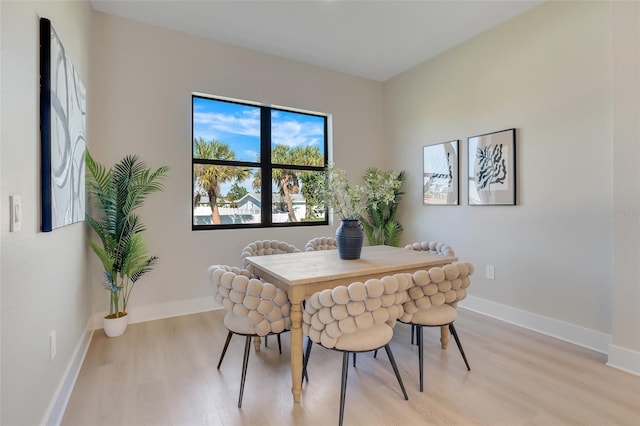 dining area with light wood finished floors and baseboards