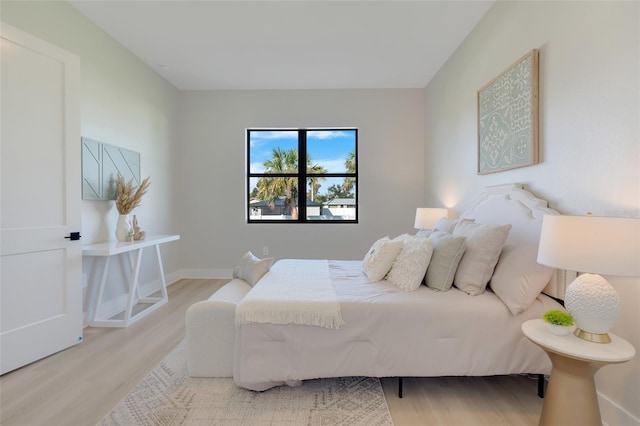 bedroom featuring light wood-style flooring and baseboards