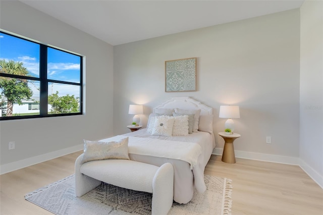 bedroom with light wood finished floors and baseboards