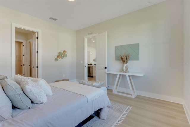 bedroom with visible vents, light wood-type flooring, and baseboards