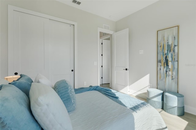 bedroom with baseboards, visible vents, and a closet