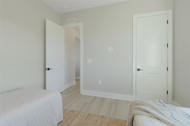 bedroom featuring baseboards, visible vents, and light wood-type flooring