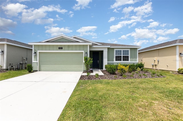 ranch-style house featuring board and batten siding, a front yard, driveway, and an attached garage