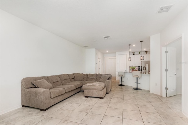 living area with light tile patterned floors, visible vents, and recessed lighting