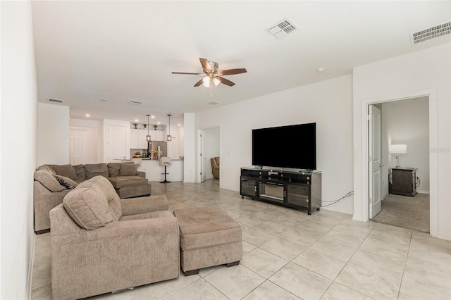 living area featuring visible vents, light tile patterned floors, and ceiling fan