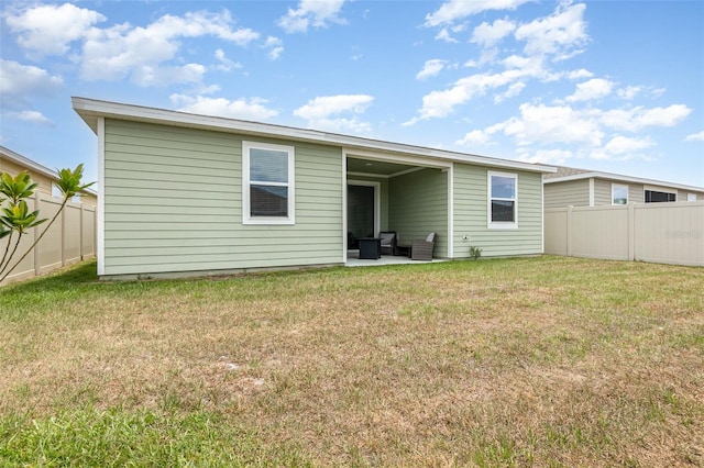 back of house featuring a patio, a yard, and fence