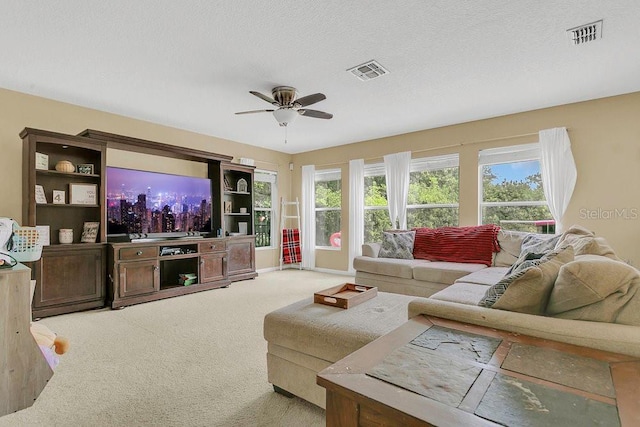 living area with visible vents, a ceiling fan, and light carpet
