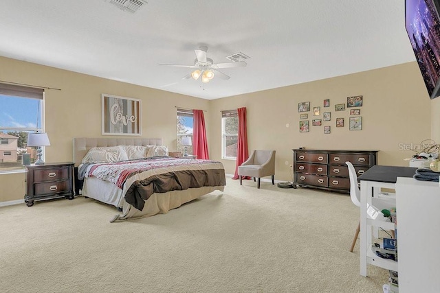 carpeted bedroom with baseboards, visible vents, and multiple windows