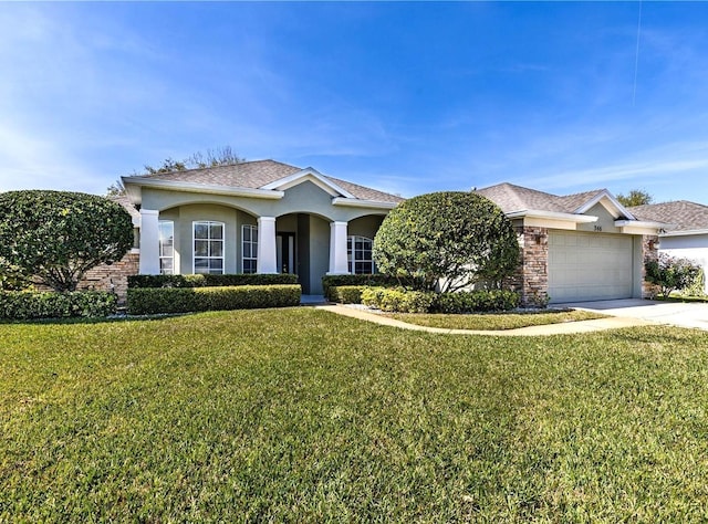 ranch-style house featuring stucco siding, a front yard, concrete driveway, and an attached garage