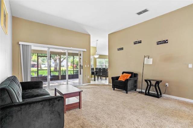 living room with baseboards, visible vents, a wealth of natural light, and carpet flooring