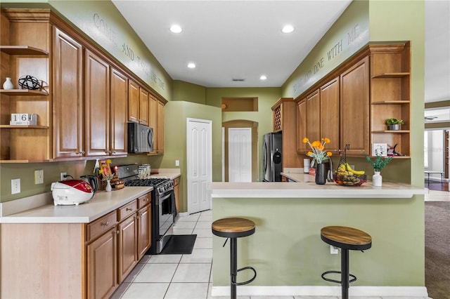 kitchen featuring open shelves, black appliances, a breakfast bar area, a peninsula, and light countertops
