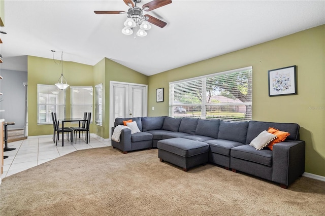 living area featuring baseboards, light carpet, a ceiling fan, and lofted ceiling