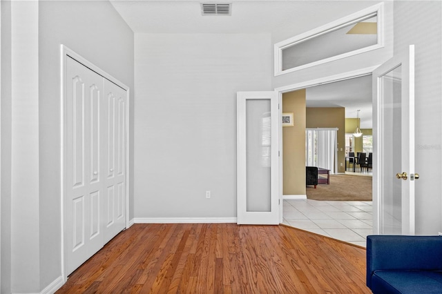 interior space with wood finished floors, visible vents, baseboards, and a closet