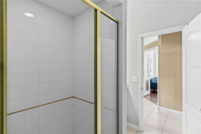 ensuite bathroom with a stall shower, ensuite bathroom, tile patterned floors, and baseboards