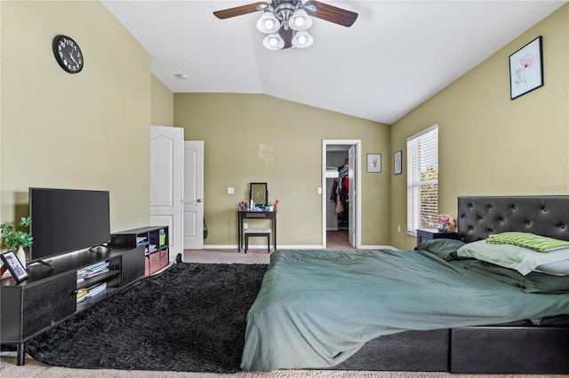 bedroom with a closet, a walk in closet, vaulted ceiling, carpet, and baseboards