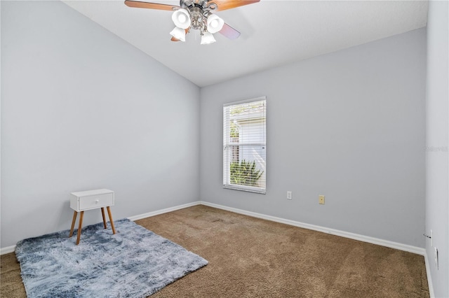 carpeted spare room featuring a ceiling fan, lofted ceiling, and baseboards