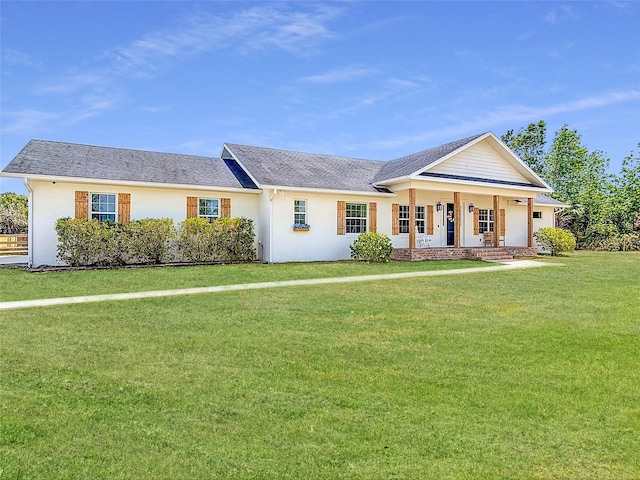 view of front facade featuring covered porch, stucco siding, a front yard, and roof with shingles