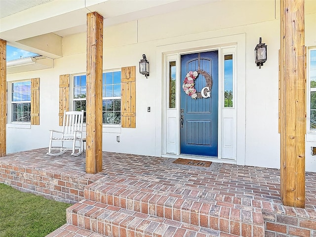 entrance to property with stucco siding and a porch