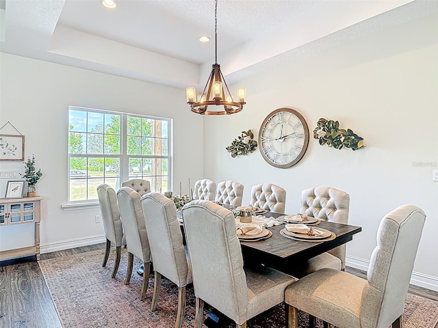 dining area with recessed lighting, a chandelier, a tray ceiling, dark wood-type flooring, and baseboards