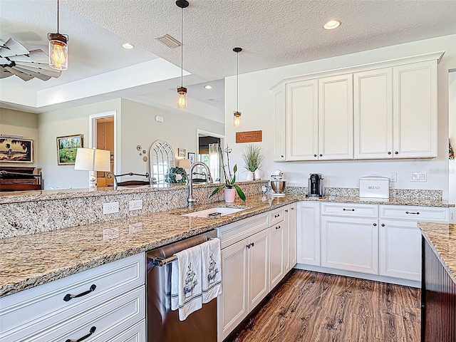 kitchen featuring a sink, dark wood-style flooring, stainless steel dishwasher, hanging light fixtures, and white cabinets
