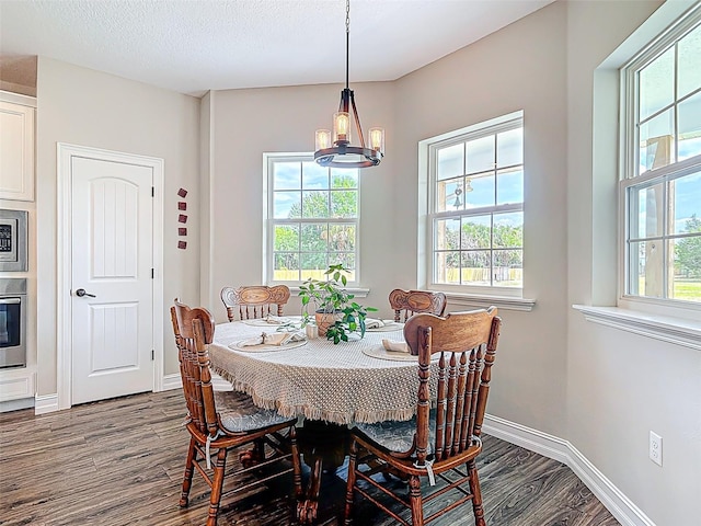 dining space with dark wood-style flooring and baseboards