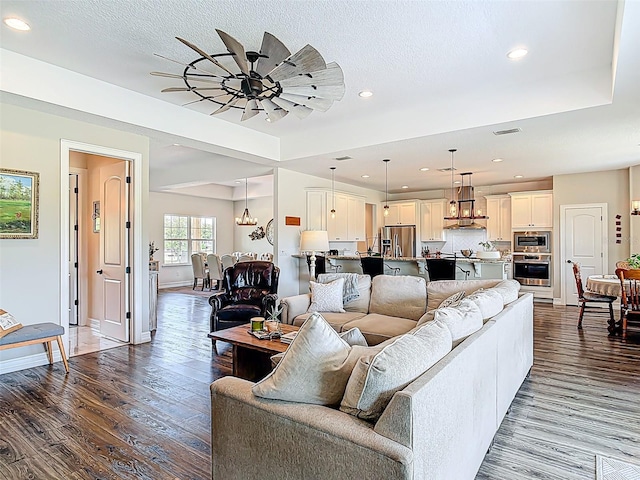 living room featuring recessed lighting, visible vents, baseboards, and dark wood finished floors