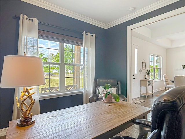 dining room featuring wood finished floors, crown molding, and baseboards