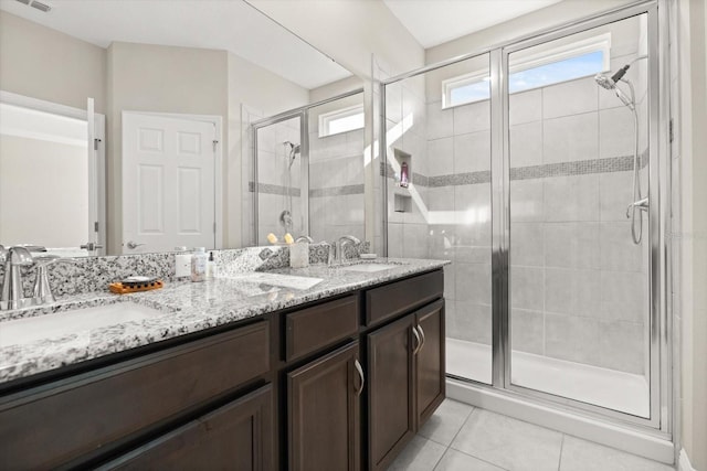 bathroom with a stall shower, tile patterned floors, and double vanity