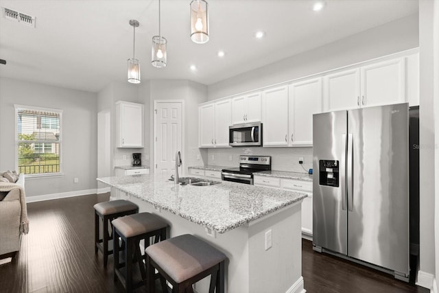 kitchen featuring stainless steel appliances, a sink, dark wood finished floors, white cabinetry, and recessed lighting