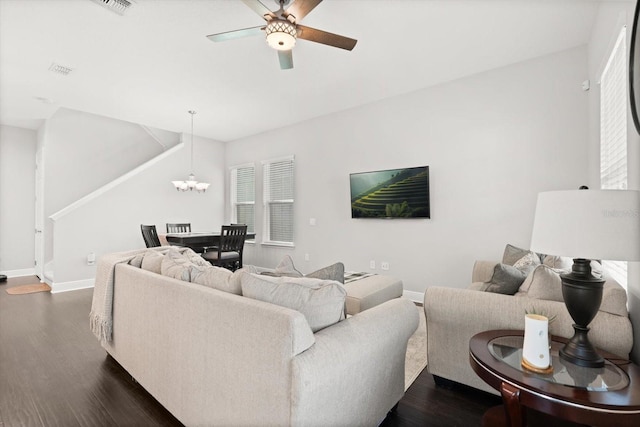living room with ceiling fan, baseboards, dark wood-style floors, and a chandelier
