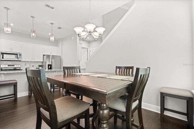 dining space with a chandelier, baseboards, dark wood finished floors, and recessed lighting